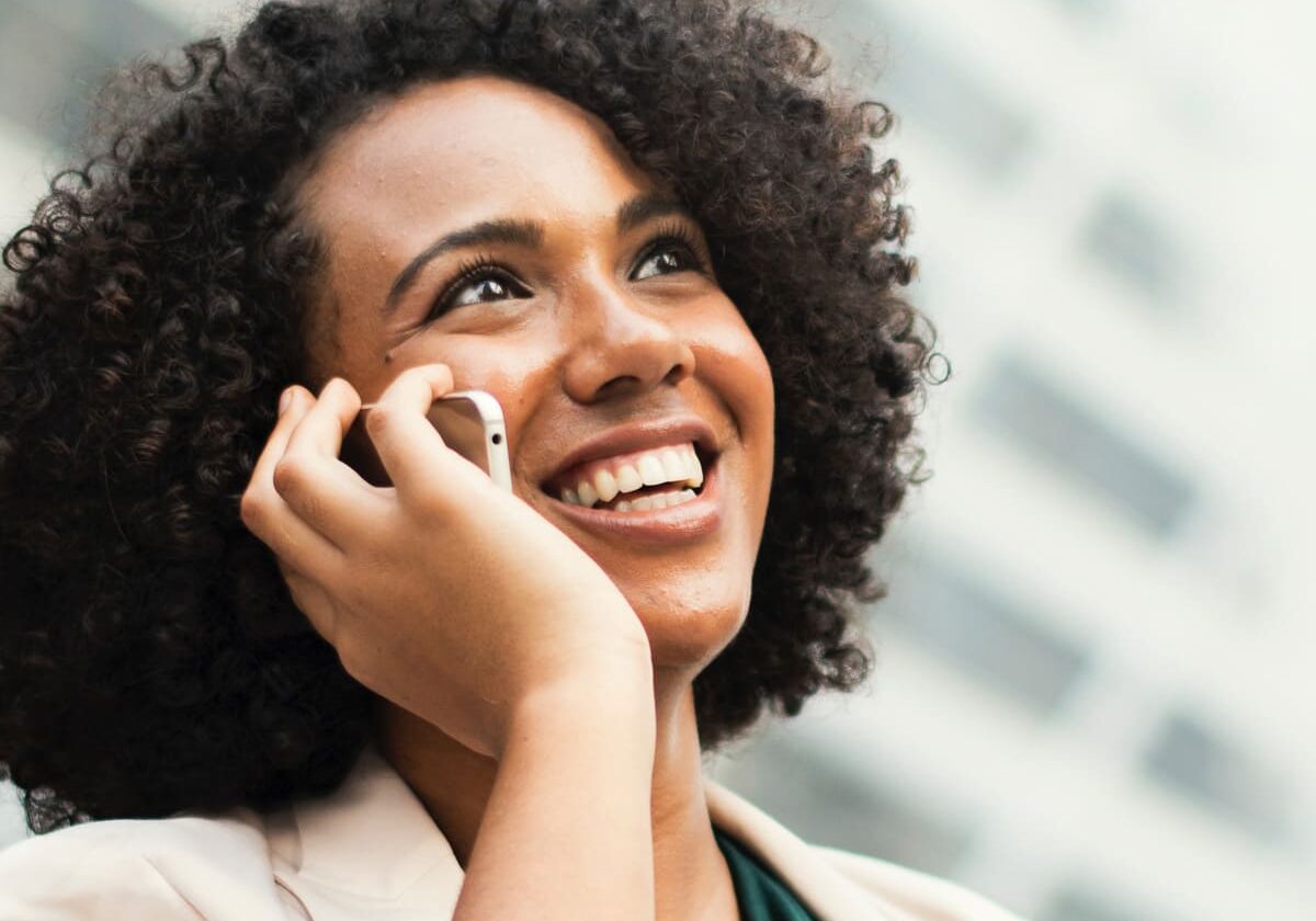 Person smiling outdoors during a coaching-focused moment
